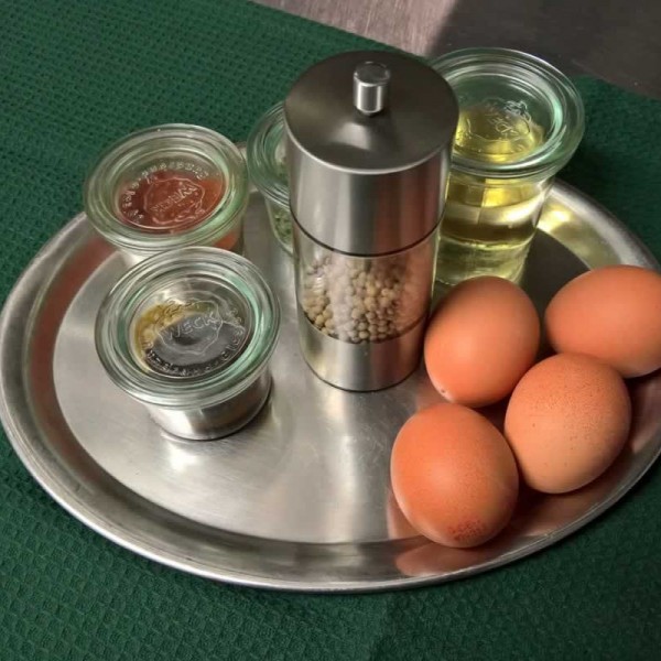 Eier, Öl und Gewürze auf Edelstahltablet