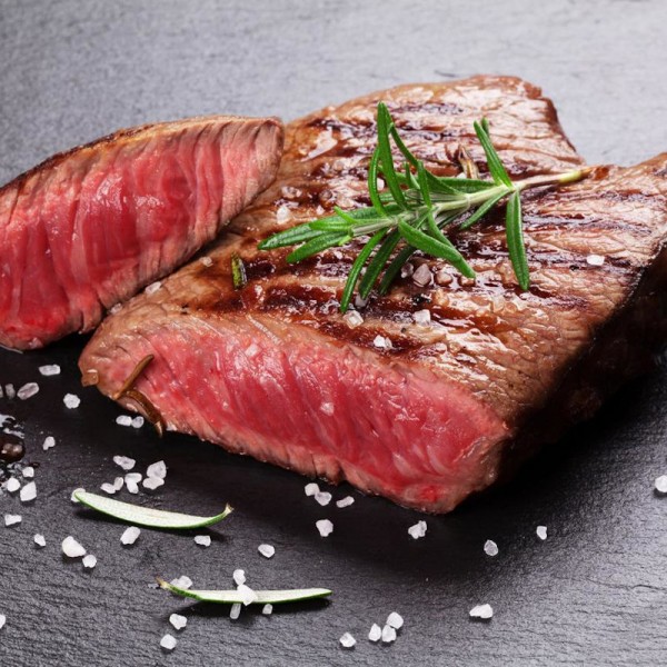 Flank Steak medium-rare gegrillt auf Schieferplatte mit Rosmarin und grobem Meersalz