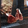 Nahaufnahme des Dry Agers. Man sieht ein T-bone Steak mit Etikett und ein Tomahawk Steak mit Etikett.